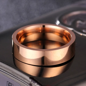 Makro-Detail des rosévergoldeten, polierten Edelstahl-Flachrings auf schwarzer Fläche