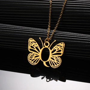 Macro-opname van de gouden vlinderhanger met opengewerkt detail en gepolijste ketting