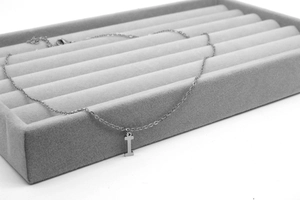 Detail der Halskette mit I-Anhänger und O-Kette aus poliertem Edelstahl auf grau