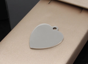 Close-up of heart-shaped stainless steel pet ID tag with a silver mirror-polished finish