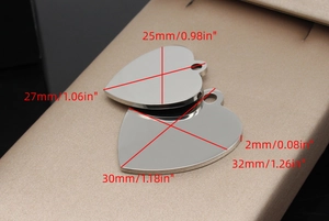 Close-up of heart-shaped stainless steel pet ID tags with polished silver finish and sizes