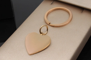 Close-up of a rose gold heart-shaped stainless steel pet ID tag on a beige jewelry box