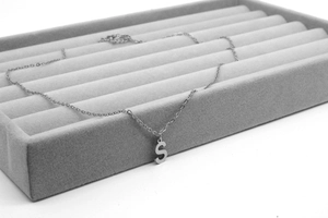 Detailaufnahme einer minimalistischen Edelstahl-Halskette mit dem Großbuchstaben S