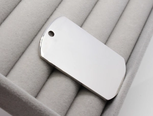 Close-up of polished silver stainless steel pet ID tag with smooth mirror finish