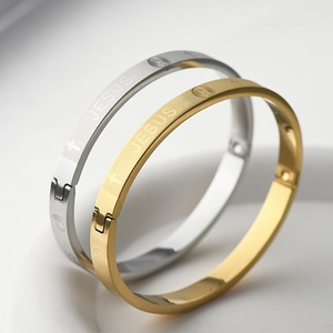 Gros plan des bracelets Jésus or et argent avec gravures religieuses et détails de croix