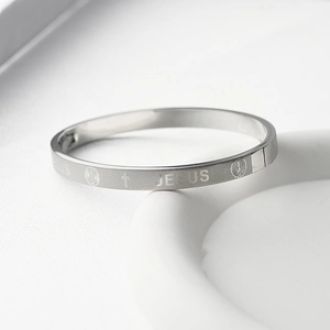 Gros plan du bracelet Jésus en acier titane argenté avec croix et motifs gravés