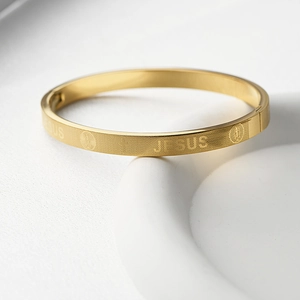 Détail du bracelet Jésus en acier doré avec gravure de croix et fermoir à charnière