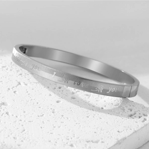 Detail showing laser engraved I Love You text and rose pattern on silver steel bangle