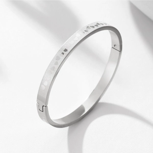 Detail of silver steel heart engraved bangle with matte finish and secure clasp
