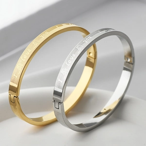 Detail of gold and silver steel bangles with I Love You engraving and brushed texture