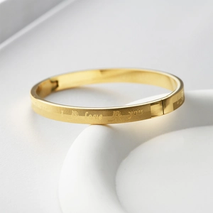 Detailed view of golden stainless steel bracelet with grid texture and I Love You engraving