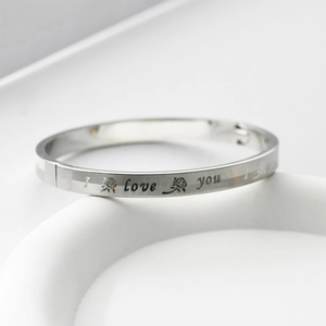 Detail of silver stainless steel bangle with I love you text and rose engraving