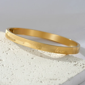 Gold stainless steel bangle featuring rose patterns and forever love engravings