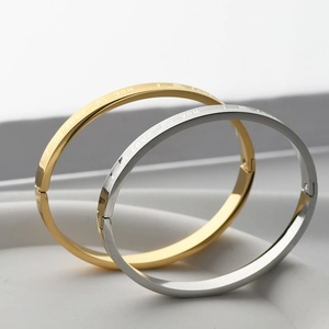 Close-up of gold and silver couple bracelets with I Love You engraving and heart patterns