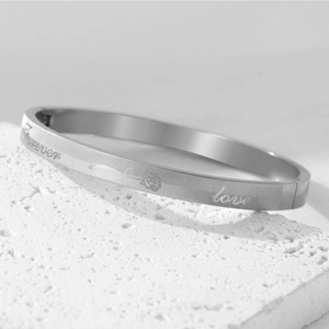 Detailed view of silver titanium steel bangle with forever love engraving and rose pattern