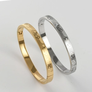 Close-up of titanium steel love heart bangles with mesh texture and hinge closure
