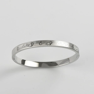 Close-up of titanium steel bangle with heart cutouts and diagonal brushed texture