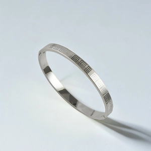 Detail shot of silver titanium steel bracelet with engraved Greek Key pattern and buckle clasp