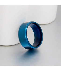 Detalle de un anillo minimalista de acero de titanio azul cepillado sobre base cerámica