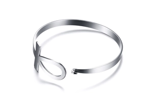 Macro shot of silver stainless steel open bangle with Egyptian Ankh cross symbol