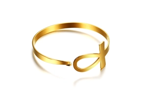 Macro detail of gold-tone stainless steel Ankh cross symbol on adjustable cuff bracelet