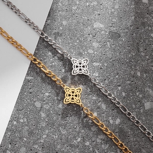 Makroansicht der Figaro-Kette und hohlen Kleeblatt-Anhänger in Gold und Silber