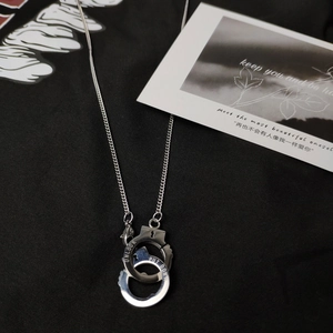 Gros plan d'un collier menottes argenté avec gravure UNLOCK sur tissu noir