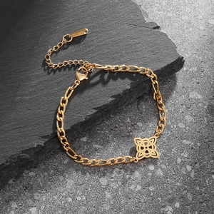 Goldenes Edelstahl-Figaro-Armband mit keltischem Knoten auf dunklem Stein-Hintergrund