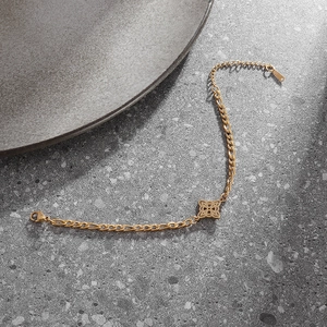 Nahaufnahme der goldenen Figaro-Kette aus Edelstahl mit hohlem Kleeblatt-Anhänger