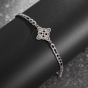 Makroaufnahme von Silbernem Figaro-Armband mit Keltenknoten auf dunkler Steintextur