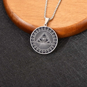 Macro-opname van zilveren Oog van de Voorzienigheid hanger met vrijmetselaar symbolen