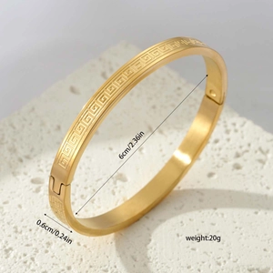 Titanium steel gold bangle with Greek key pattern and engraved dimensions measurements