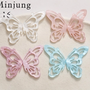 Detailed view of hollow acetate butterfly charms in white pink blue and purple colors