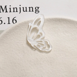Macro shot of a translucent white butterfly acetate pendant for DIY handmade jewelry crafts