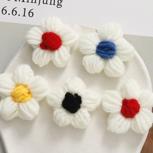 Detail of five handmade crochet puff flowers with colorful centers for DIY accessories