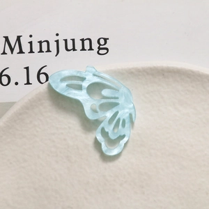 Macro shot of light blue hollow butterfly pendant with marble texture for DIY jewelry