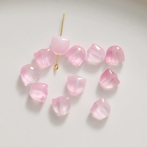 Vue macro de perles tulipes en verre rose translucide pour bijoux artisanaux