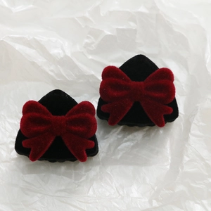 Primer plano de mini pinzas para el cabello con lazos de terciopelo rojo y negro