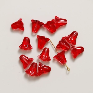 Vue macro d'une perle tulipe en verre rouge translucide sur tige dorée pour bijoux DIY