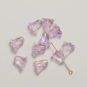 Vue macro de perles en verre muguet violet translucide avec des tiges en métal doré