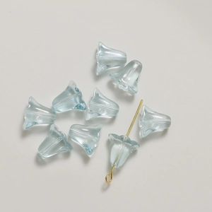 Vue macro de perles en verre tulipe bleu clair translucides pour création de bijoux