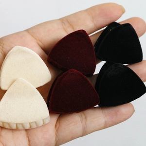 Detalle de pequeñas pinzas para el cabello flocadas en beige, granate y negro aterciopelado