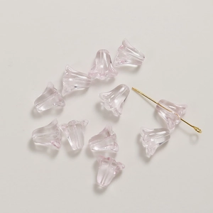 Détail de perles tulipes en verre rose translucide avec tige dorée pour bijoux DIY