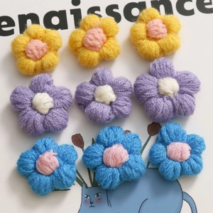 Dettaglio di nove mini fiori all'uncinetto in colori pastello per accessori fai-da-te