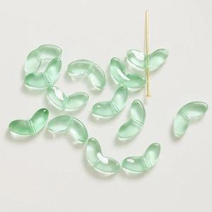 Gros plan de perles en verre vert translucide en forme de pétale pour bracelet DIY