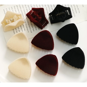 Detalle de mini pinzas triangulares de pelo con acabado aterciopelado en varios colores