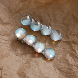 Lot de deux barrettes à perles bleu clair irisées sur fond de papier texturé unique