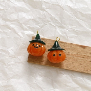 Nahaufnahme von Mini-Harzkürbis-Anhängern mit Zauberhüten für DIY-Schmuckherstellung