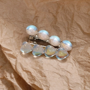 Détail d'une pince à cheveux de 4 cm avec perles irisées et pierres bleues en cœur