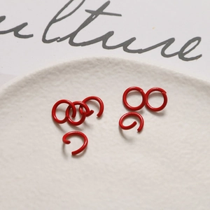 Dettaglio macro di anellini aperti laccati rossi per accessori per gioielli fai-da-te